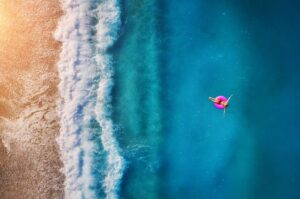 person floating on raft in beach