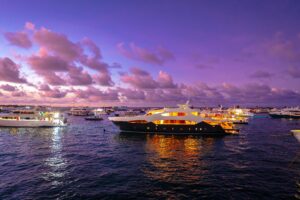 yacht on ocean with sunset in background 